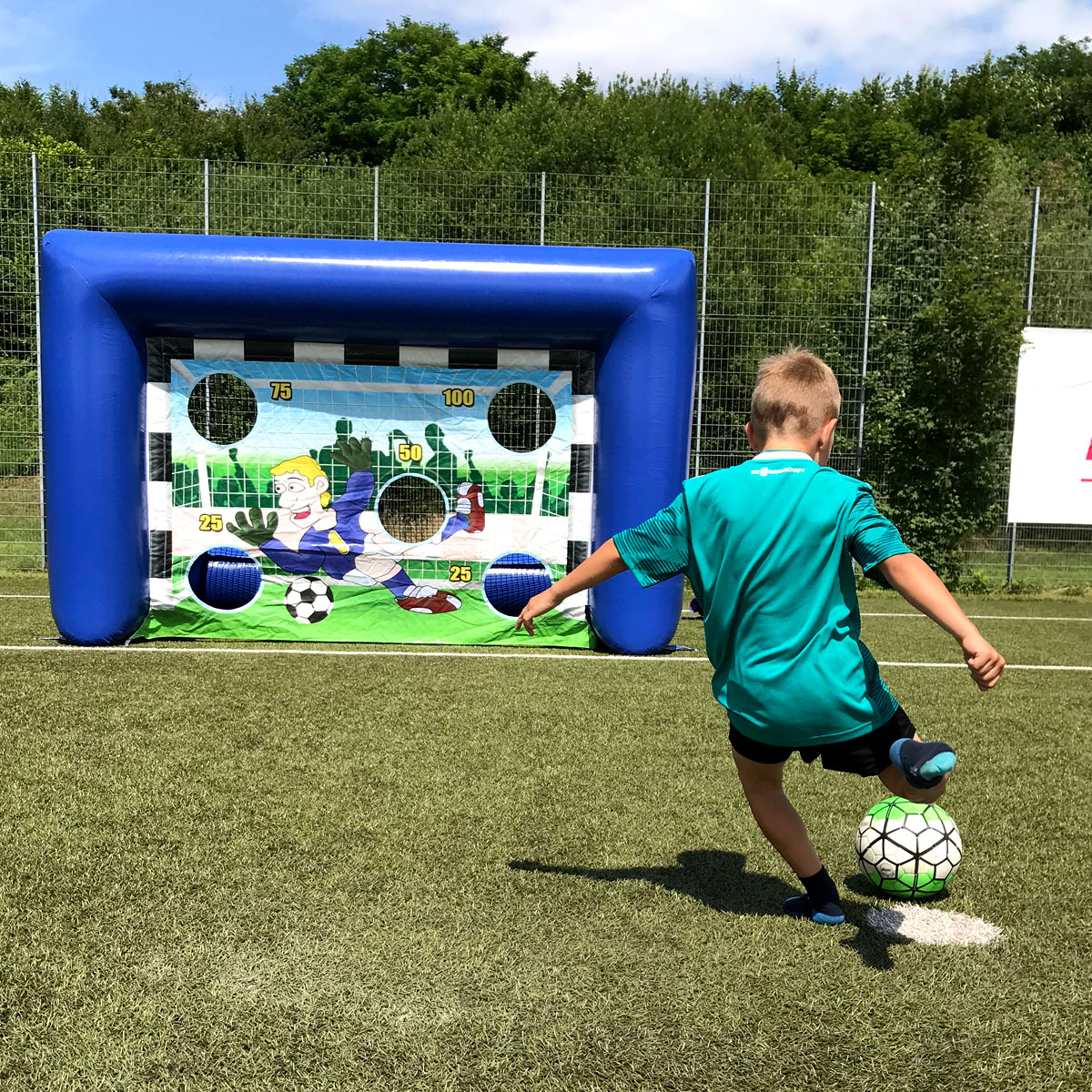 Kind spielt die blaue Fussball Klett Wand