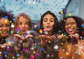 4 Frauen pusten Konfetti