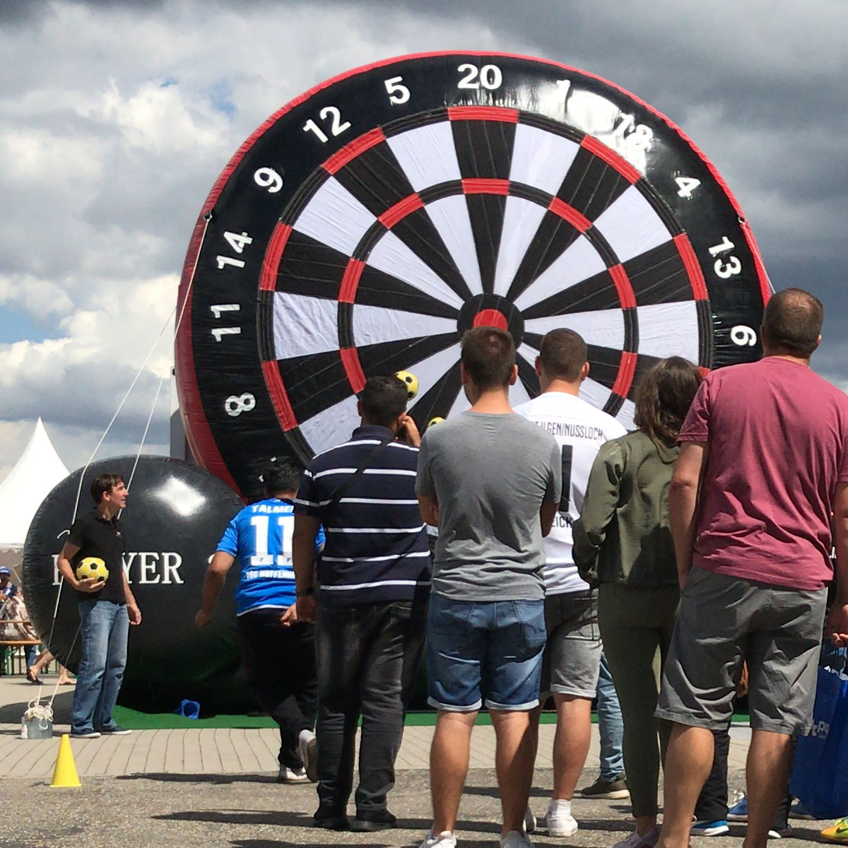 Menschen schauen sich die aufblasbare Dartscheibe an