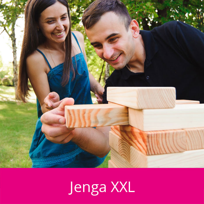 Junger Mann und junge Frau spielen in der Nahaufnahme ein großes Jenga Spiel